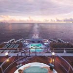 una-coppia-si-gode-il-tramonto-nella-vasca-idromassaggio-durante-una-crociera-sulla-Queen-Mary-2