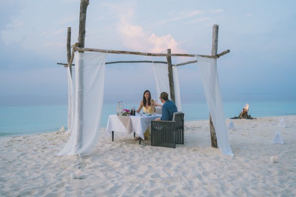 coppia che celebra la luna di miele in spiaggia al tramonto