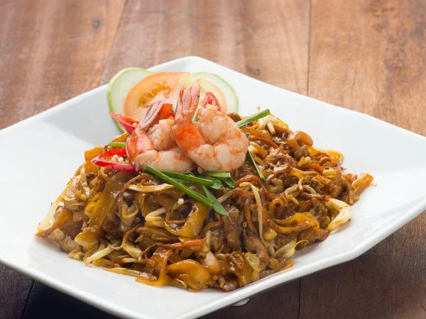 Assaporare il Char Kway Teow, il celebre piatto di noodles saltati malesi
