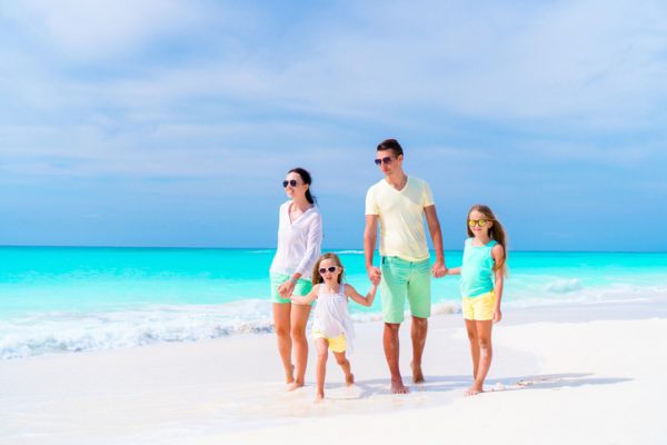 famiglia-felice-ai-caraibi-si-tiene-per-mano-in-spiaggia