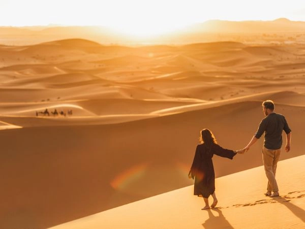 coppia che cammina nel deserto del Sahara